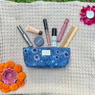 Floral everyday pouch with makeup essentials on textured mat