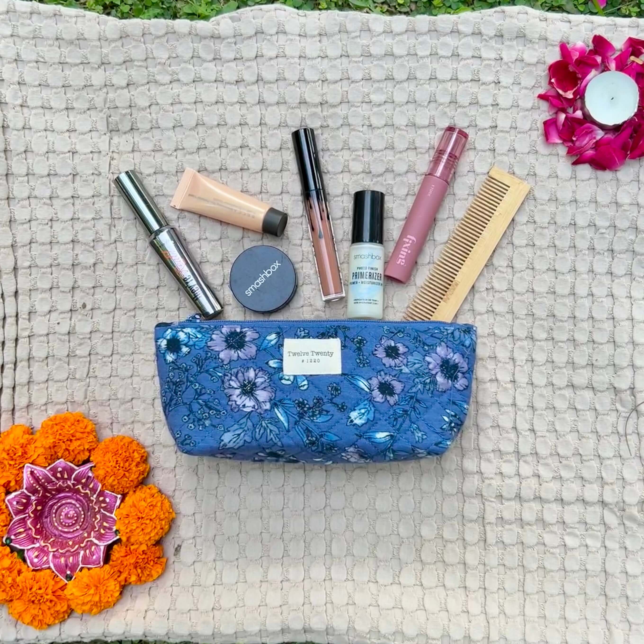 Floral everyday pouch with makeup essentials on textured mat